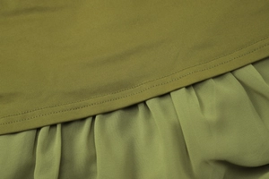 Détail macro des coutures en dentelle et mousseline vert olive avec double rangée de fils