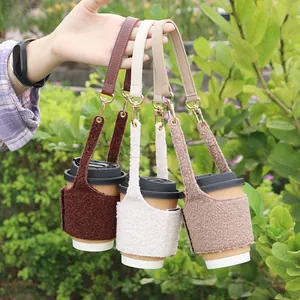 Close-up of fuzzy sherpa coffee cup sleeves with leather handles in outdoor setting