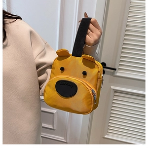 Detail of yellow nylon cartoon bear handbag featuring 3D ears and top handle