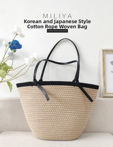 Detail of minimalist cotton rope woven tote bag with contrast black handles on a sofa