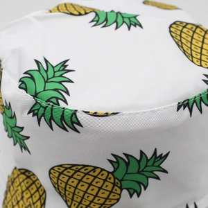 Close-up of white bucket hat with pineapple pattern showing cotton fabric texture and stitching