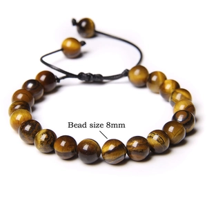 Macro shot of 8mm natural tiger eye stone beads with adjustable black braided rope