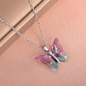 Macro shot of butterfly pendant with purple gradient resin and sparkling zircon inlay