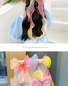 Detail of rainbow organza hair bow with pearl tassels and colorful streaming ribbons