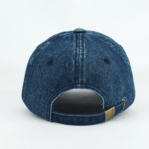 Detail of vintage copper metal buckle and adjustable strap on washed denim cap