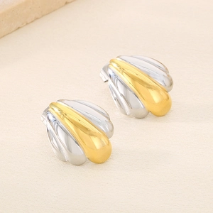 Détail macro de boucles d'oreilles mixtes en métal avec design en éventail bicolore poli