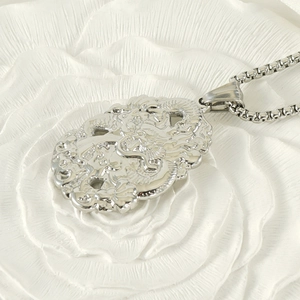 Vue détaillée d'un collier pendentif dragon argenté avec gravure traditionnelle chinoise