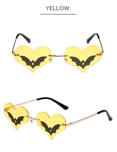 Detail view of heart-shaped yellow lenses with black bat motifs and gold metal frame