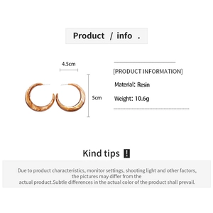 Detailed macro view showing the size and dimensions of amber resin C-shape hoop earrings
