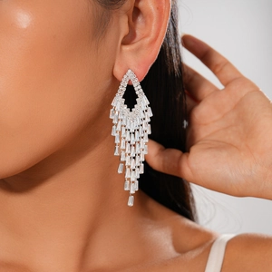 Macro detail of geometric diamond tassel earrings with zircon stones on model's ear
