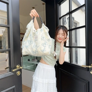 Detail of canvas tote bag with blue butterfly patterns and woven rope handles