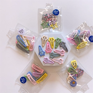 Detail of macaron hair clips in star and heart shapes with gift packaging bags