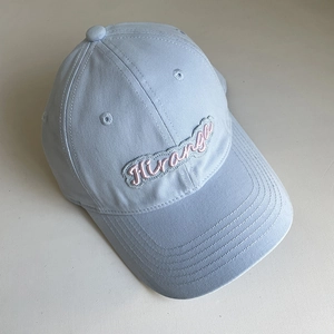 Close-up of pink Hiranga letter embroidery on light blue cotton twill baseball cap