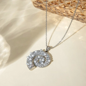 Macro detail van een zilveren schelphalsketting met sprankelende strass steentjes en parels