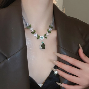 Dettaglio della collana in argento con zircone verde a goccia e gemme a fiori bianchi