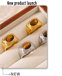 Detail of vintage oval tiger eye rings with textured gold and silver plated bands
