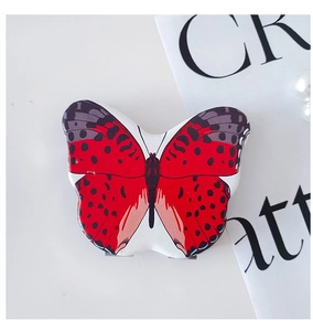 Close-up of a butterfly-shaped folding pocket mirror with red and black wing textures