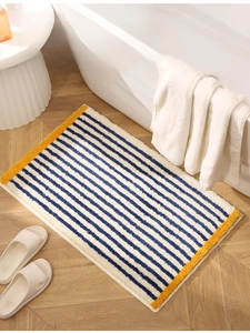 Detail of plush blue and white striped bathroom mat with vibrant yellow edges