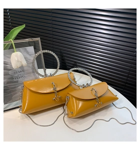 Detail of yellow leather handbags with rhinestone-encrusted circular handles and gold chains
