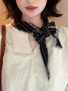 Detail of a vintage striped fabric scarf necklace with small floral patterns tied in a bow