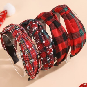 Set of four Christmas headbands with red plaid and snowflake patterns on a clear stand