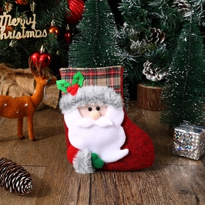 Detail of red Christmas stocking with 3D Santa Claus and plaid cuff for holiday decor