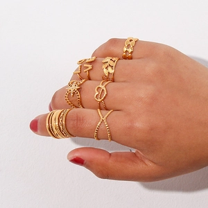 Detail view of gold fashion ring set featuring LOVE engraving and hollow leaf designs
