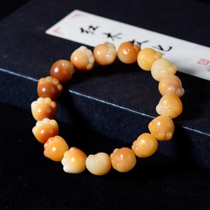 Macro detail of amber cat paw carved beads on a textured blue jewelry gift box