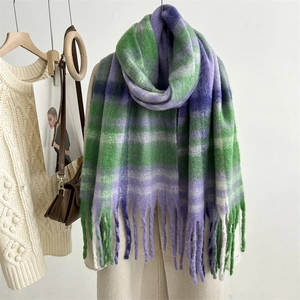 Detailed close-up of soft green and purple plaid mohair scarf texture with fringed edges