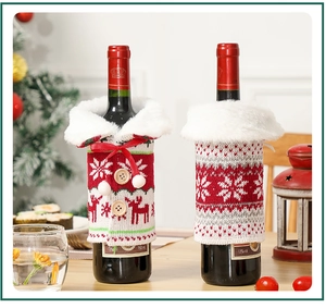 Close-up of knitted Christmas wine bottle covers with snowflakes and reindeer on a table