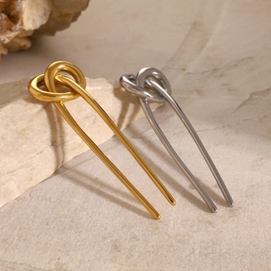 Minimalist 18k gold and silver U-shaped stainless steel hair pins on light stone surface