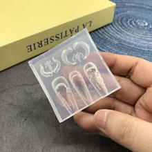 Detailed macro view of a clear silicone nail art mold featuring intricate embossed patterns