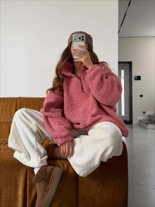 Cozy pink half-zip fleece sweatshirt with a loose fit for women in a warm home setting