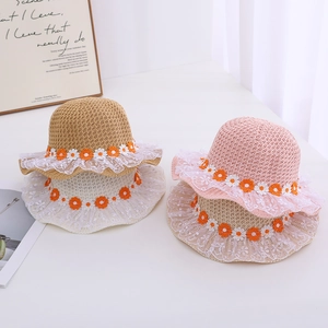 Detail of children's straw sun hats with daisy embroidery and delicate lace trim