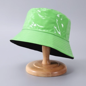 Cappello a secchiello in pelle PU verde neon lucido su supporto in legno per esterno