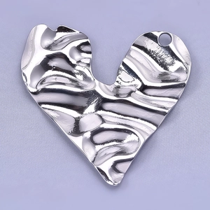 Macro detail of silver 304 stainless steel heart pendant with irregular rippled texture