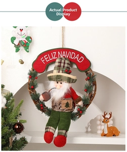 Detail of a rattan Christmas wreath featuring a plush gnome and Feliz Navidad sign