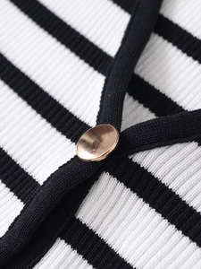Macro shot of gold metal buttons on premium black and white striped knit cardigan fabric
