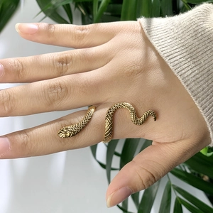 Détail d'une bague serpent plaquée or avec textures d'écailles sur le doigt