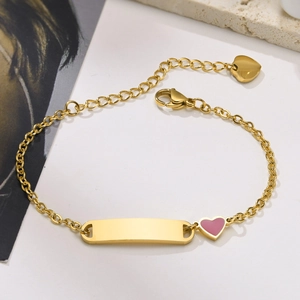 Détail d'un bracelet en acier doré avec barre vierge et breloque coeur en émail rose