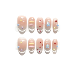 Cat-eye press-on nails with 3D colorful beads and blue floral designs on a nude gradient base