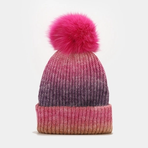Détails de la maille du bonnet dégradé avec un grand pompon en fausse fourrure