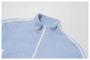 Detail of light blue fleece jacket featuring a high collar and white shoulder stripes