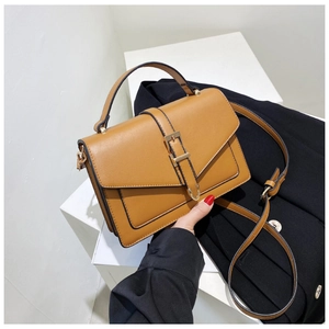 Detail of brown vintage crossbody bag featuring gold hardware and adjustable strap