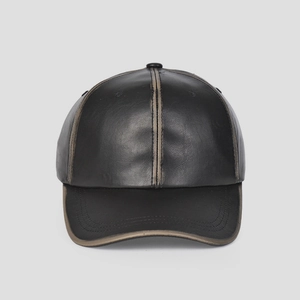 Dettaglio del berretto da baseball in pelle PU nera con eleganti cuciture beige a contrasto