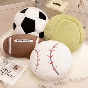 Plush sports ball pillows including soccer, football, baseball, and tennis on a white rug