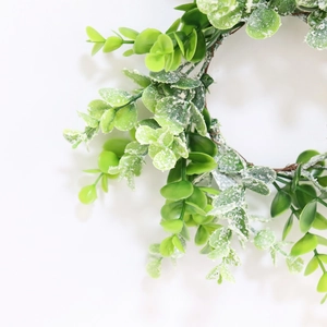 Close-up of artificial eucalyptus candle ring with frosted leaves for holiday decor