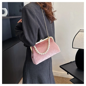 Detail showing pink velvet shell bag with quilted texture and faux pearl handle chain