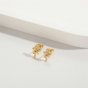 Macro shot of gold Eye of Horus stud earrings with blue gemstone and zircon inlay