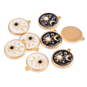 Detailed group view of gold tarot sun and moon charms with black and white enamel finish